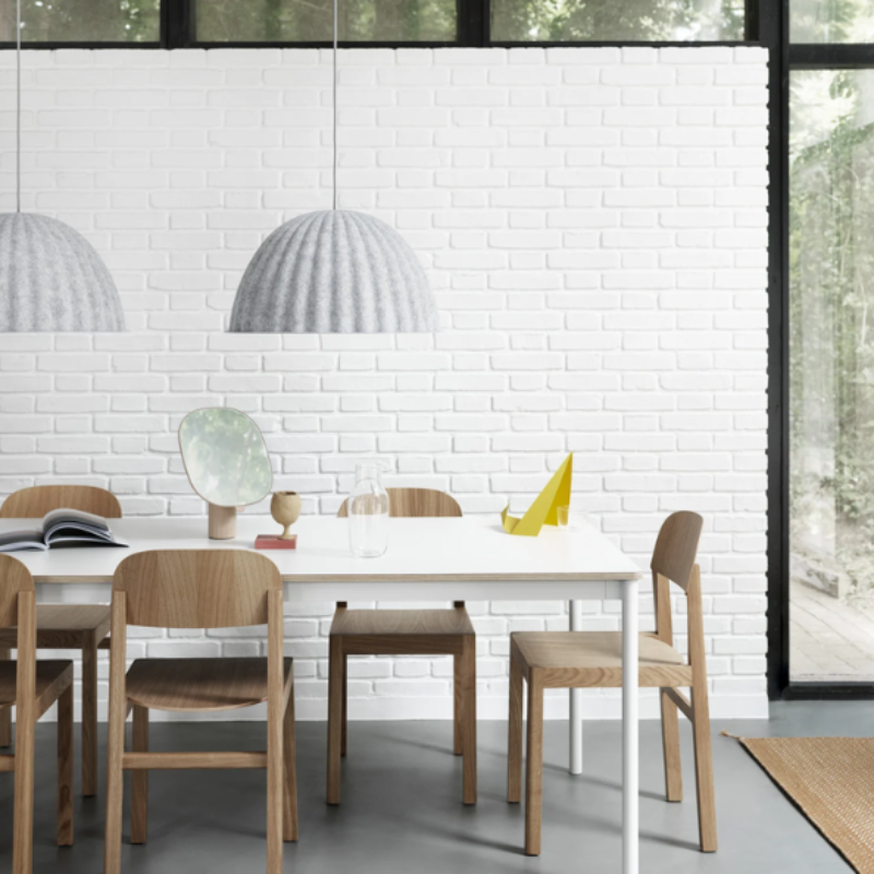 The white melange Under the Bell Pendant Lamp from Muuto in a living room.