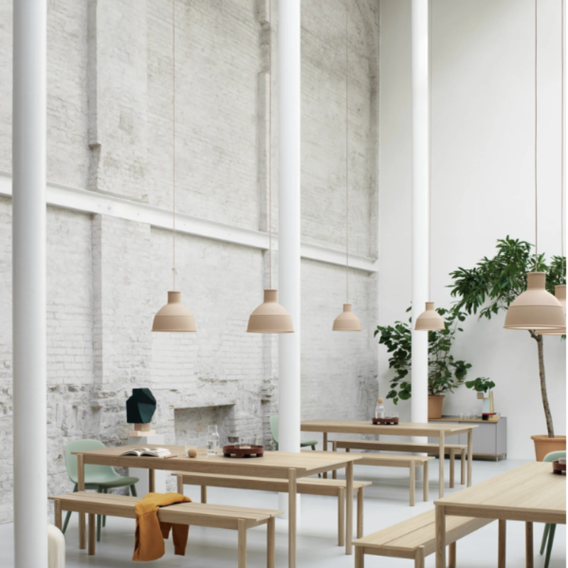 The beige rose Unfold Pendant Lamp from Muuto in a business space.