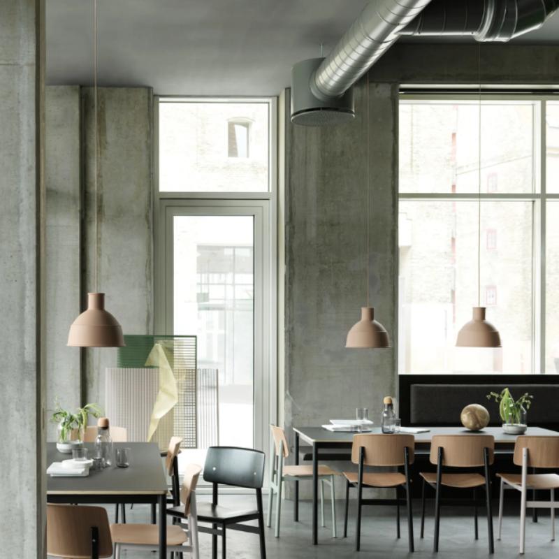 The beige rose Unfold Pendant Lamp from Muuto in a cafe.