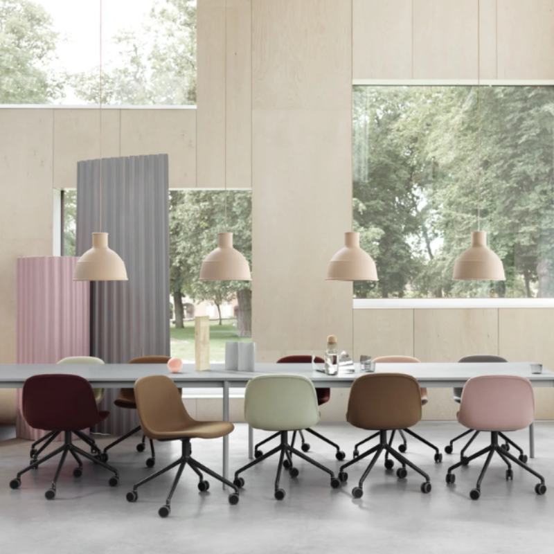 The beige rose Unfold Pendant Lamp from Muuto in a meeting room.