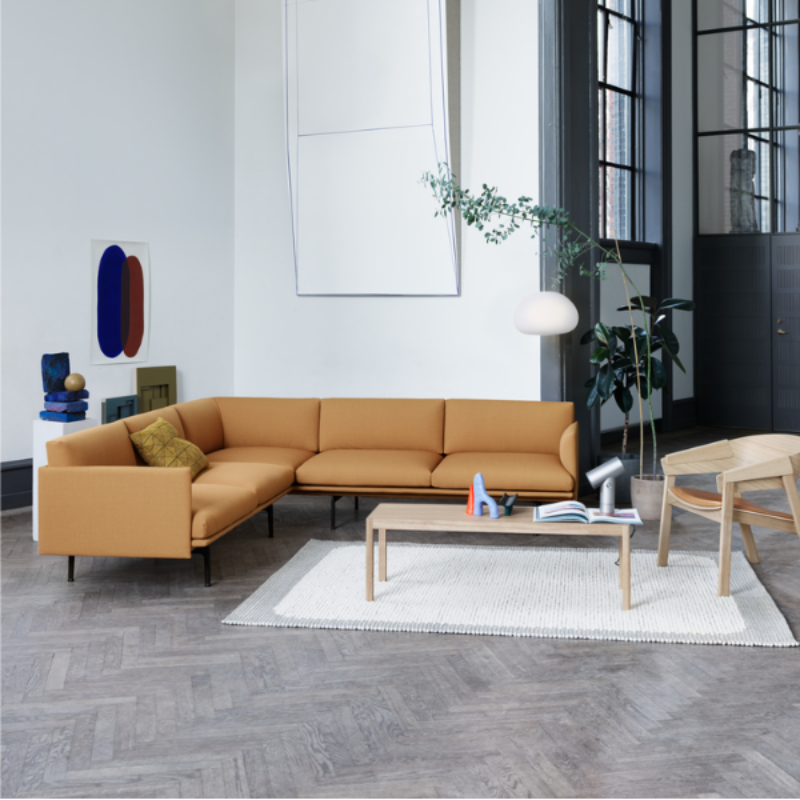 The Upholstered Cover Lounge Chair from Muuto with cognac refine leather in oak in a living room.