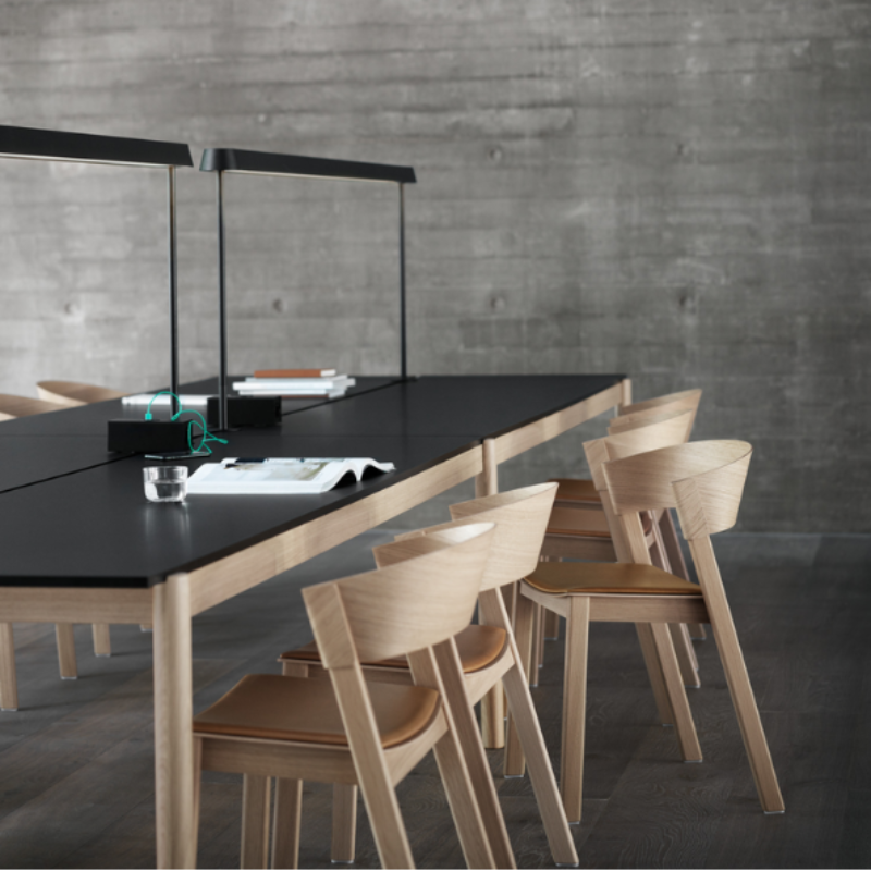 The Upholstered Cover Side Chair by Muuto with cognac refine leather in oak in a meeting room.