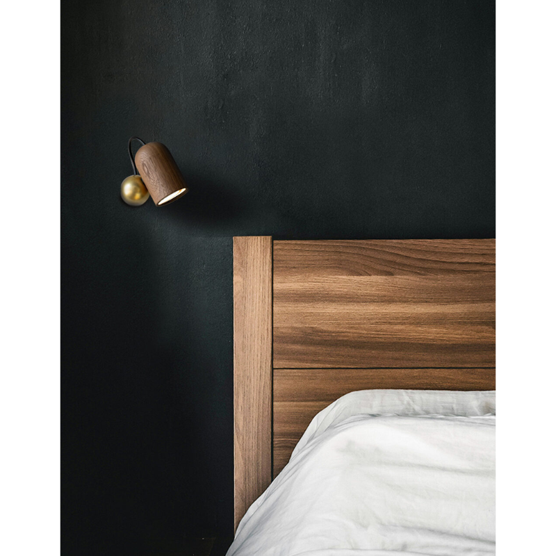 The walnut with brass Onfa Wall Lamp from Nomon in a primary bedroom.
