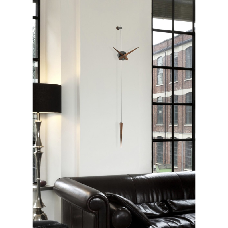 The graphite steel and walnut Punto y Coma Clock from Nomon in a living room.