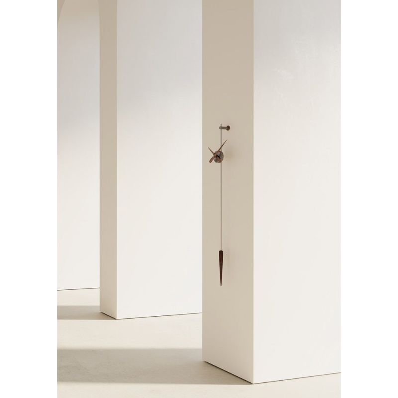 The graphite steel and walnut Punto y Coma Clock from Nomon in a studio.