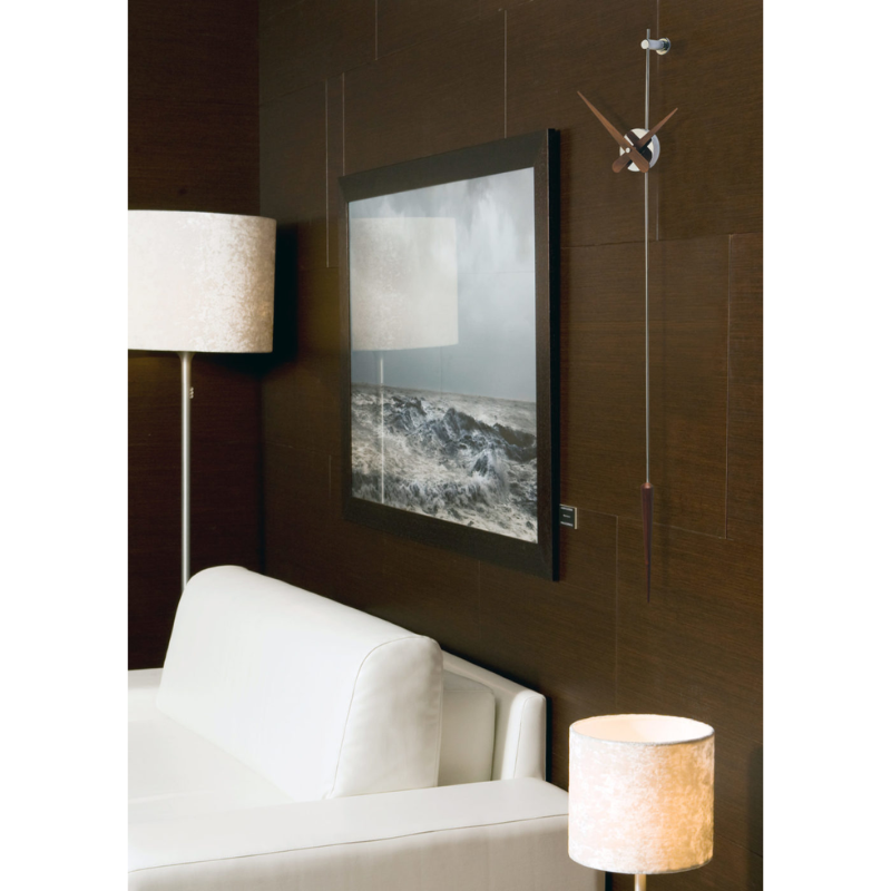 The steel and walnut Punto y Coma Clock from Nomon in a lounge.