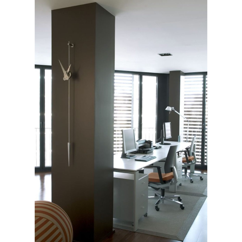 The steel Punto y Coma Clock from Nomon in a home office.