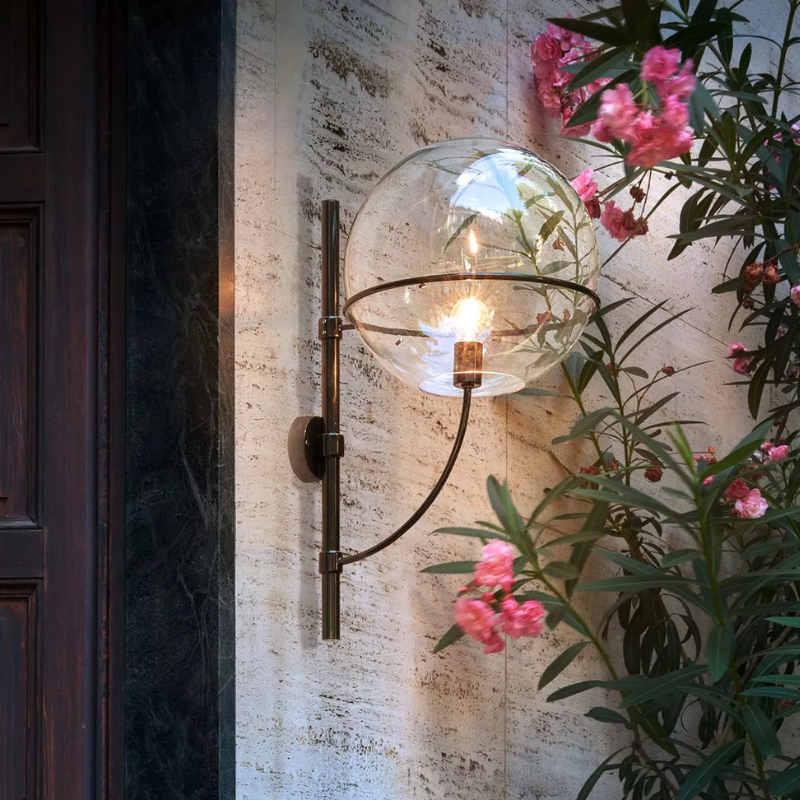 The Lyndon Outdoor Wall Sconce from Oluce next to a doorway.