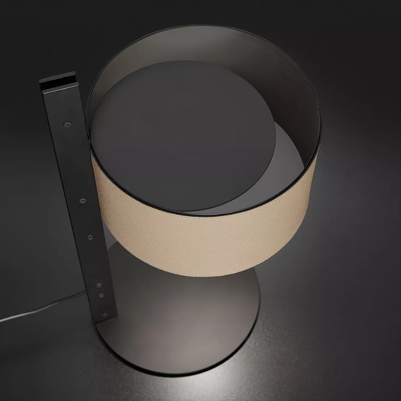 The Parallel Table Lamp from Oluce in sand leather in a studio.