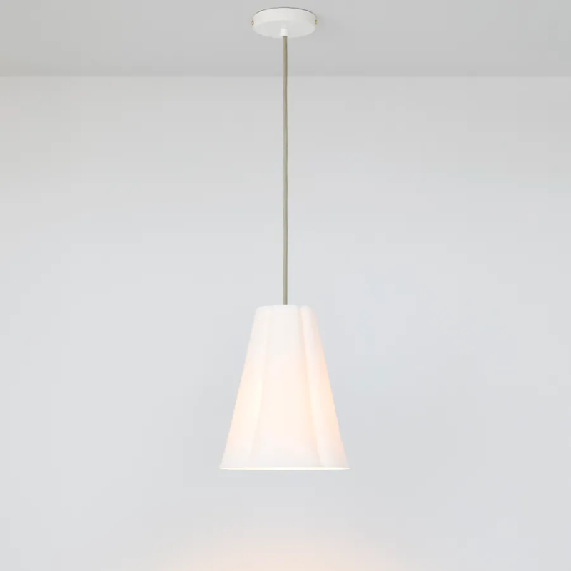 The medium Blossom Pendant from Original BTC with grey cable in a studio turned on.