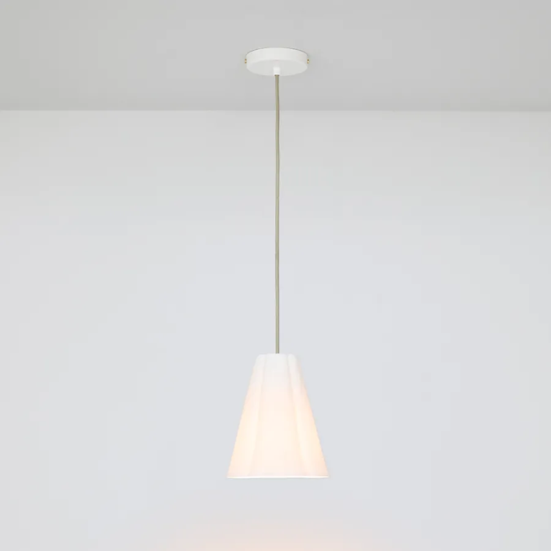 The small Blossom Pendant from Original BTC with grey cable in a studio turned on.