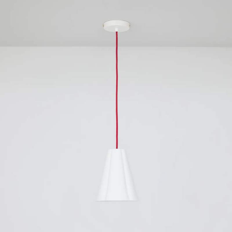 The small Blossom Pendant from Original BTC with red cable in a studio.