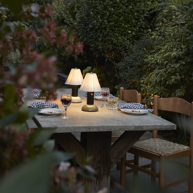 The Blossom Portable Light from Original BTC in putty grey in an outdoor family space.