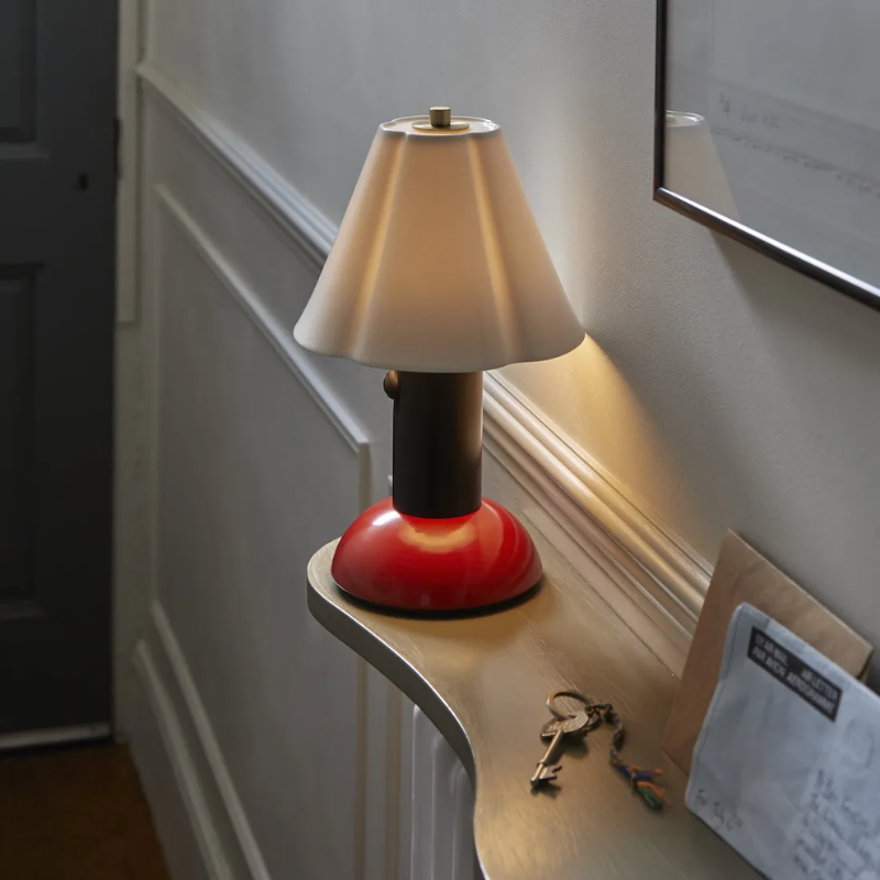 The Blossom Portable Light from Original BTC in rusty red in a living room.
