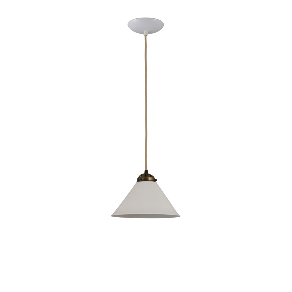 The small antique brass Cobb Pendant from Original BTC in a studio.