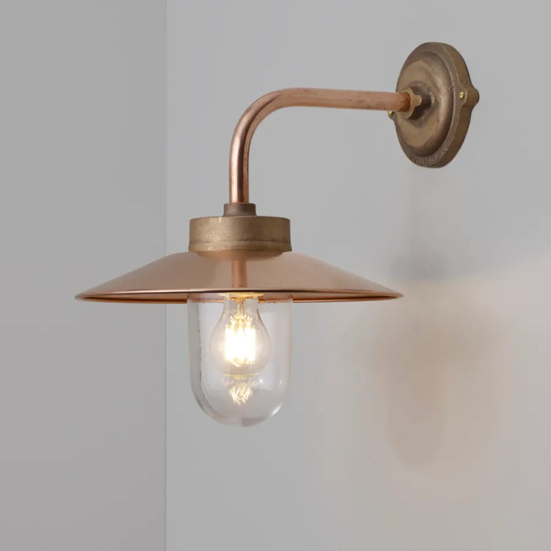 The Exterior Bracket Light from Original BTC in bronze with a clear glass diffuser in a living room.