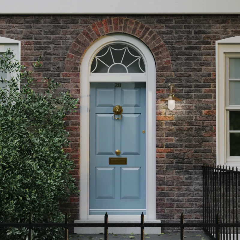 The Exterior Bracket Light from Original BTC in bronze with a frosted glass diffuser beside a doorway.