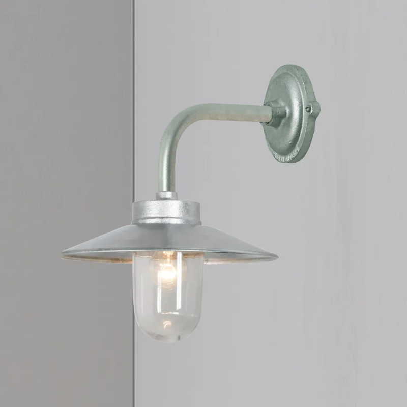 The Exterior Bracket Light from Original BTC in galvanized silver with a clear glass diffuser in a photoshoot.