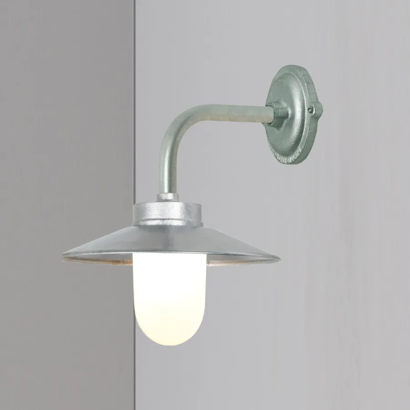 The Exterior Bracket Light from Original BTC in galvanized silver with a frosted glass diffuser in a studio.