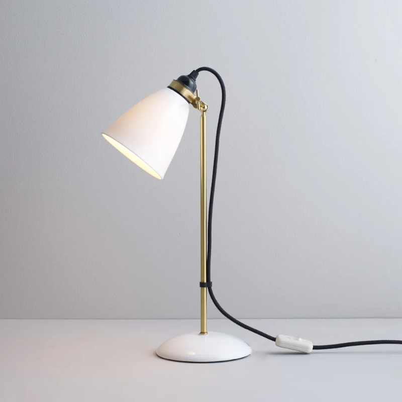 The Hector 30 Table Light from Original BTC with a black cable in a studio turned on.