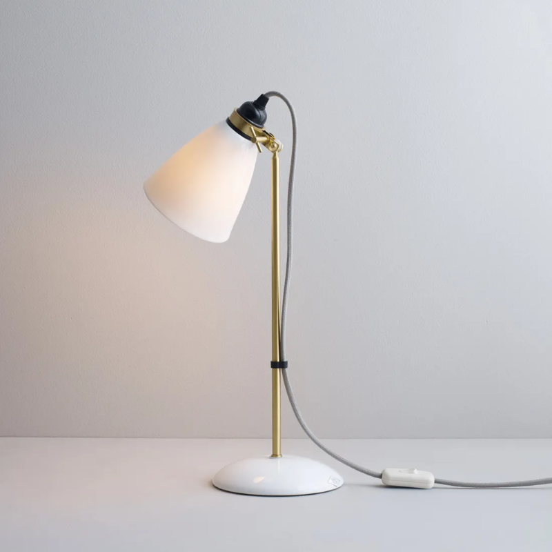 The Hector 30 Table Light from Original BTC with a grey cable in a studio from an angle turned on.