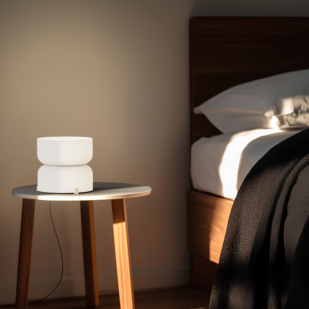 The etched white Mini Totem Table Lamp from Pablo Designs used as a bedside light.