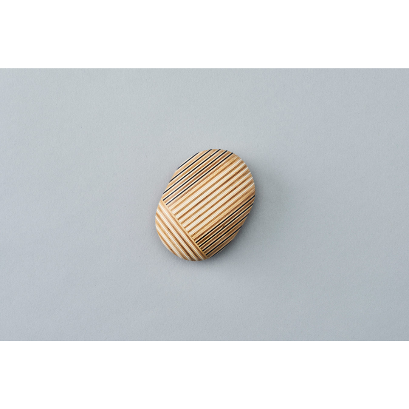 The Koishi Paperweight from Plywood Laboratory ellipse shape in navy within a studio.