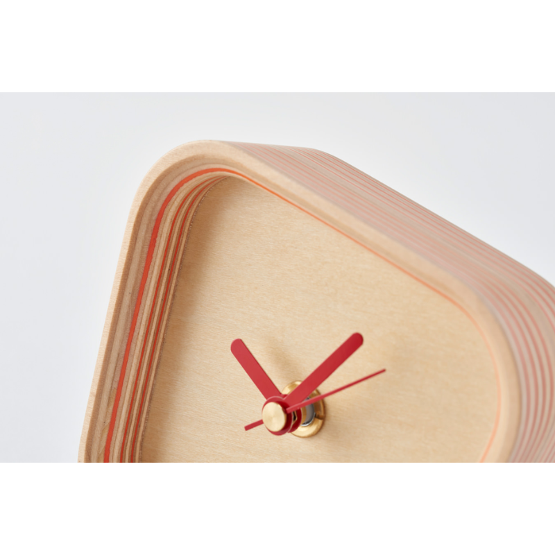 The Rotation Clock from Plywood Laboratory in orange, in a close up shot.