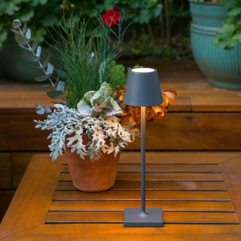 The dark gray Poldina Pro Micro from Zafferano in a garden.