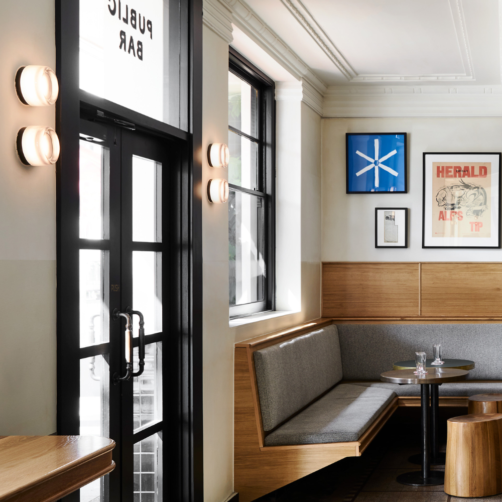 The Dimple Sconce by RBW with White Interior and Black Anodized installed in a restaurant. all-groups