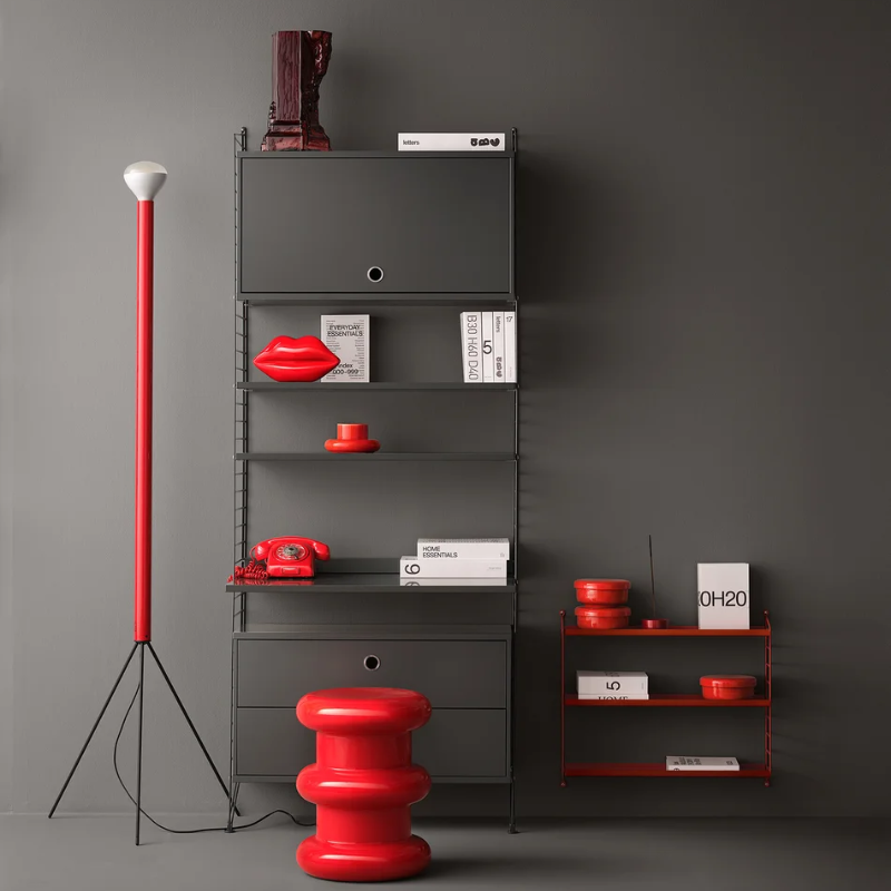 The Cabinet with Flip Door from String Furniture in dark grey in a living room.