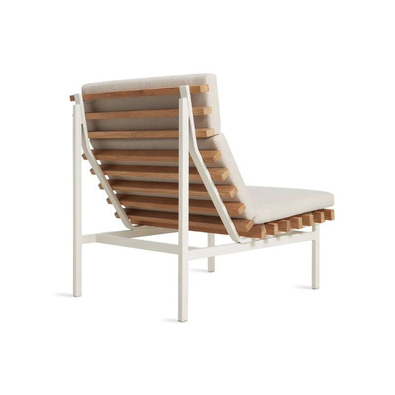 The Perch Outdoor Lounge Chair from Blu Dot with white frame and sunbrella linen upholstery from the back at an angle.