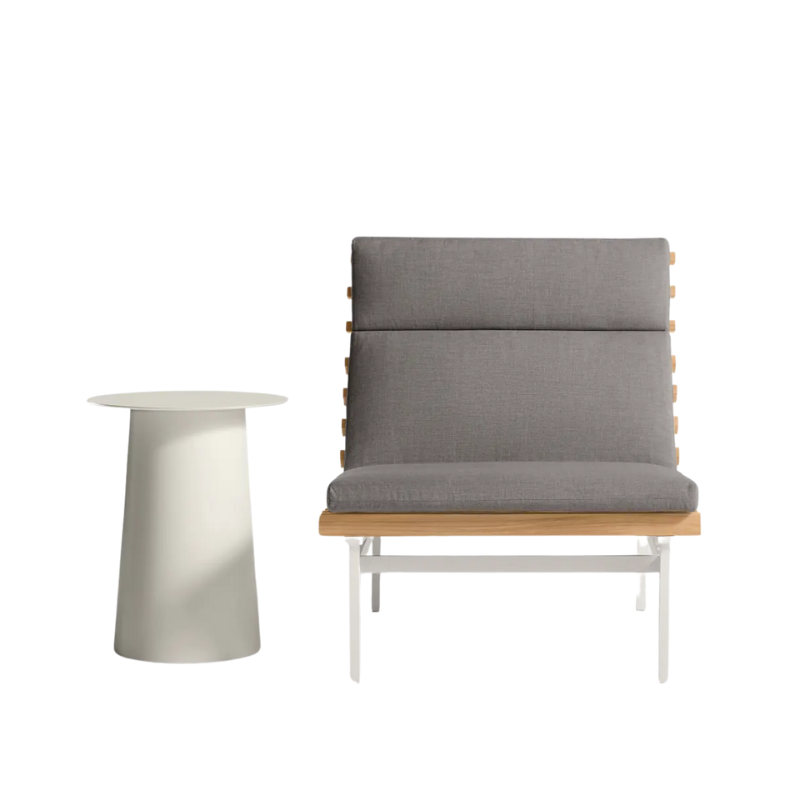 The Perch Outdoor Lounge Chair from Blu Dot with white frame and toohey charcoal upholstery with a circula side table.