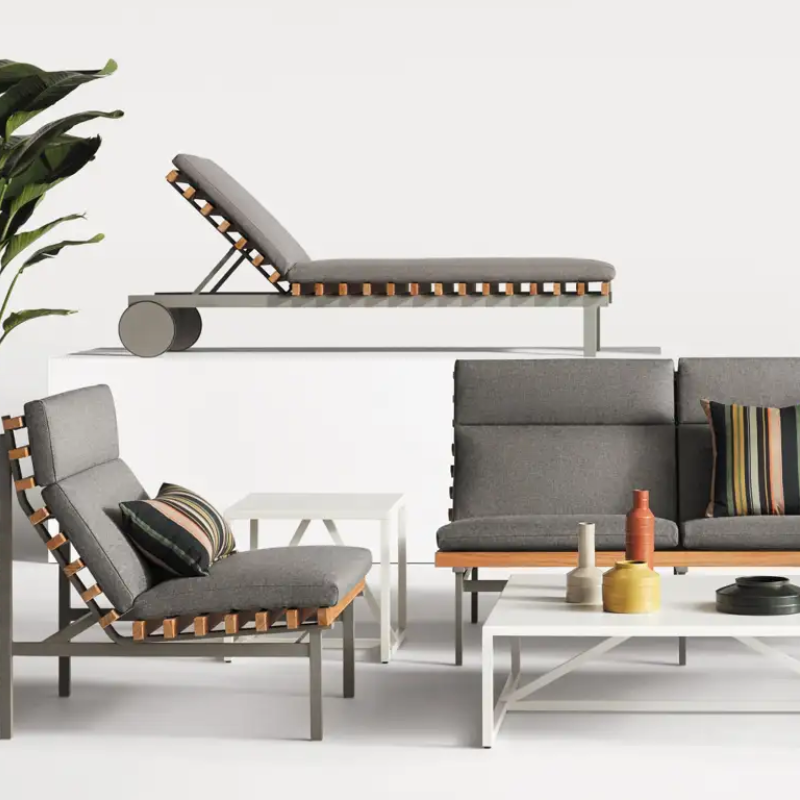 The Perch Outdoor Sun Lounger from Blu Dot with the carbon frame and toohey charcoal upholstery in a living room.