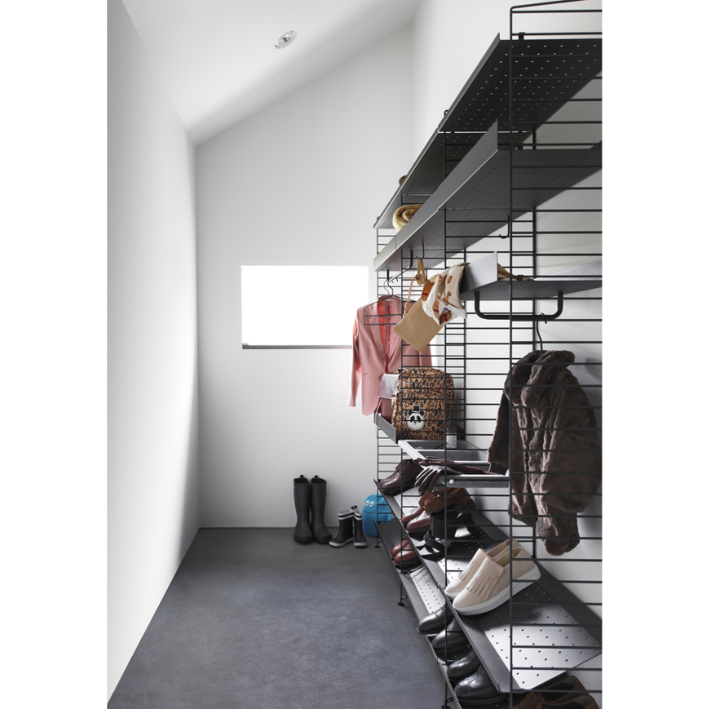 The Shoe Shelf from String Furniture in black used in a walk in closet.
