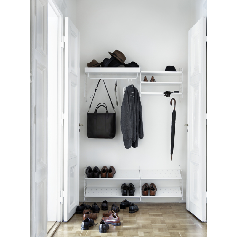 The Shoe Shelf from String Furniture in white in an entryway.