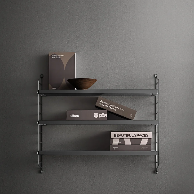 The String Pocket from String Furniture in dark grey in a family space.