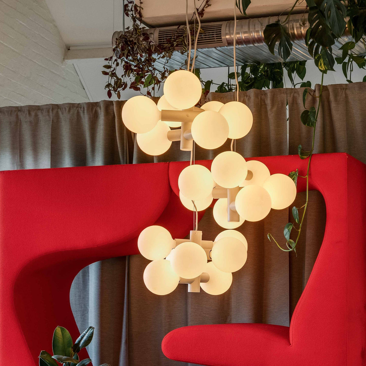 Three Echo Chandeliers by Tala Lighting in a commercial space.
