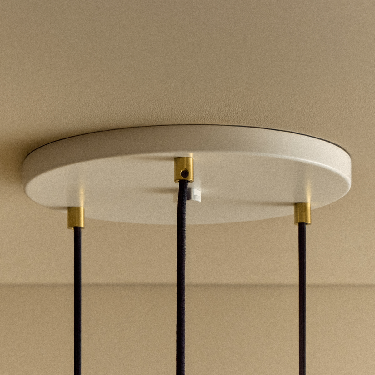 The white canopy of the Triple Pendant in Brass + Sphere IV.