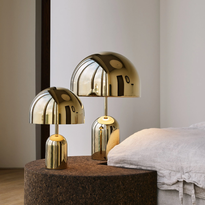 The Bell Portable LED from Tom Dixon in gold in a guest room.