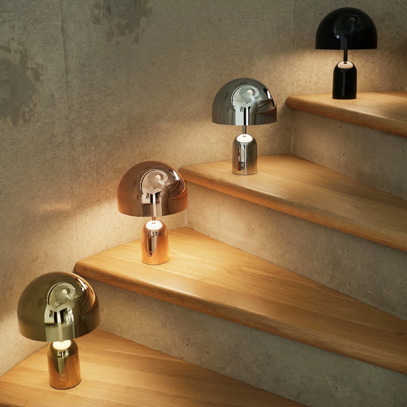 The Bell Portable LED from Tom Dixon in gold on a staircase.