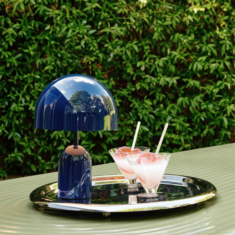 The Bell Portable LED from Tom Dixon in indigo in an outdoor dining setting.