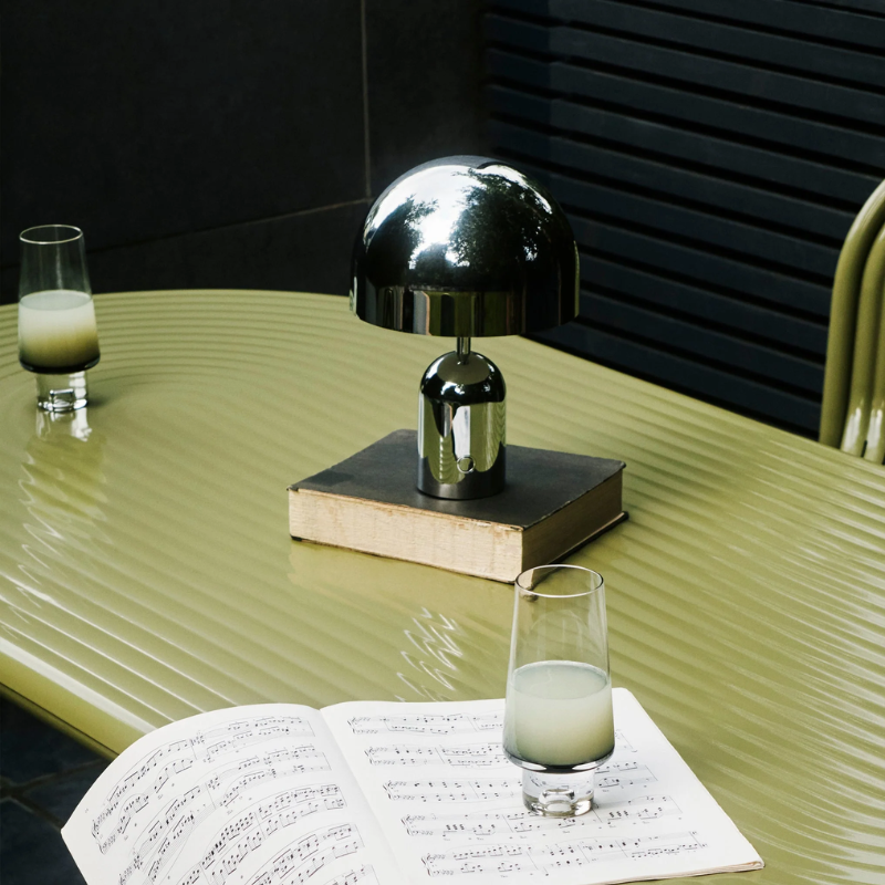 The Bell Portable LED from Tom Dixon in silver on a dining table.