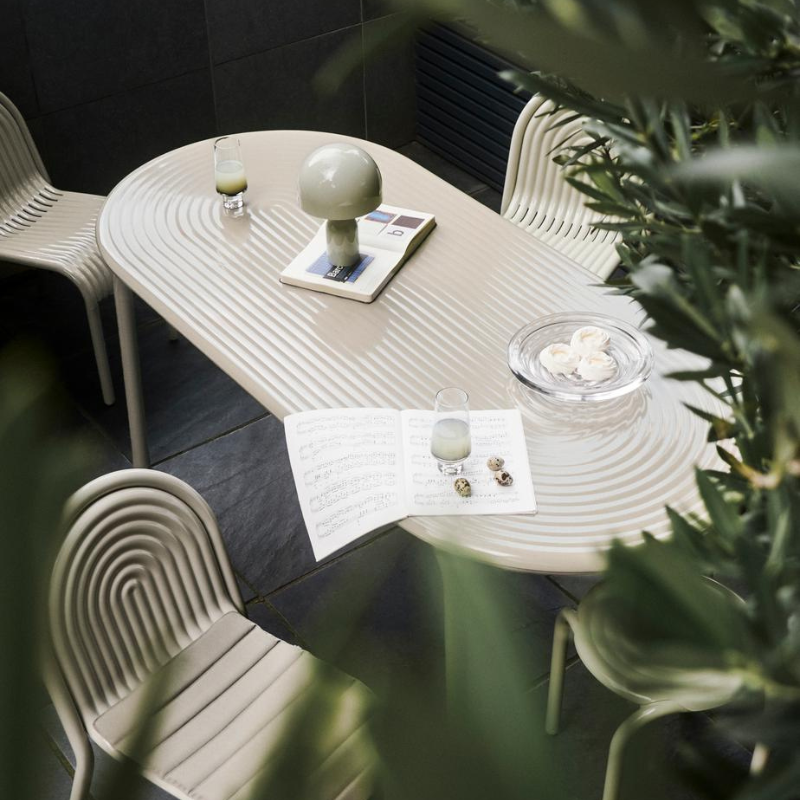 Outdoor Groove dining set in Putty by Tom Dixon on a patio.