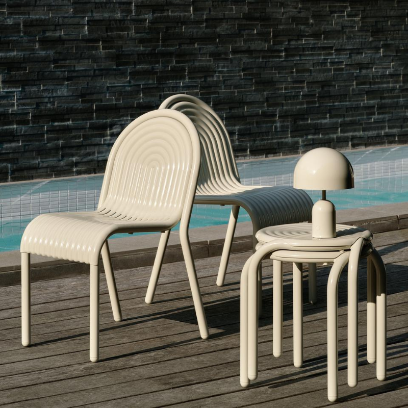 Outdoor Groove dining set in Putty by Tom Dixon on a pool deck.