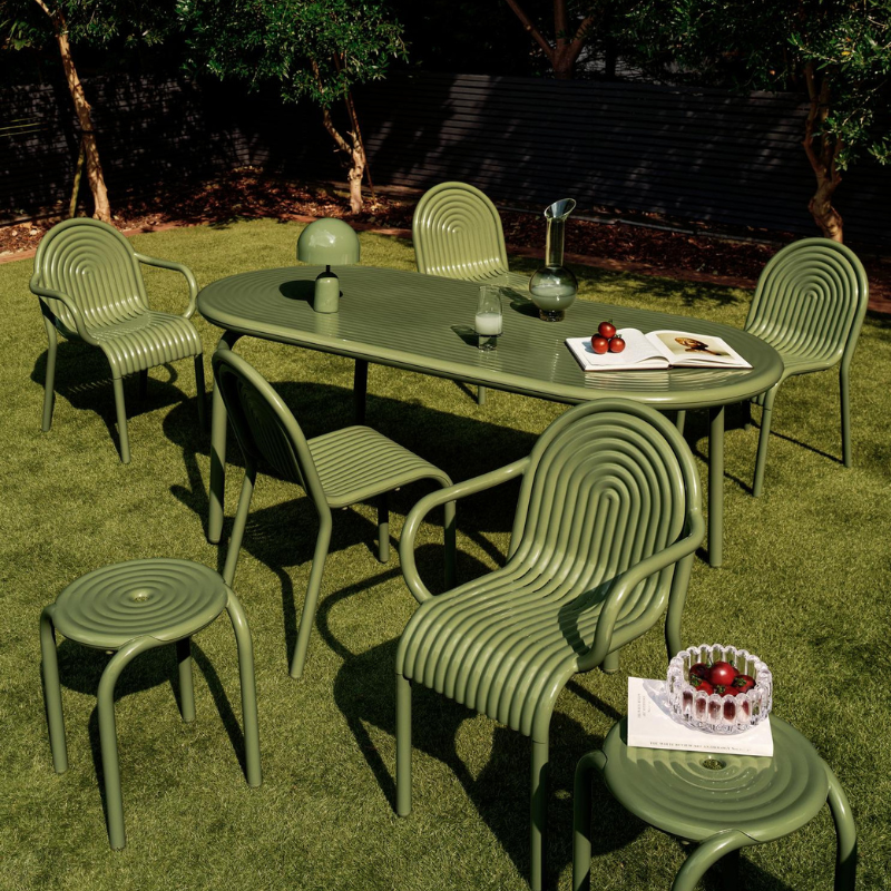 Outdoor Groove dining set in Moss by Tom Dixon in a garden.