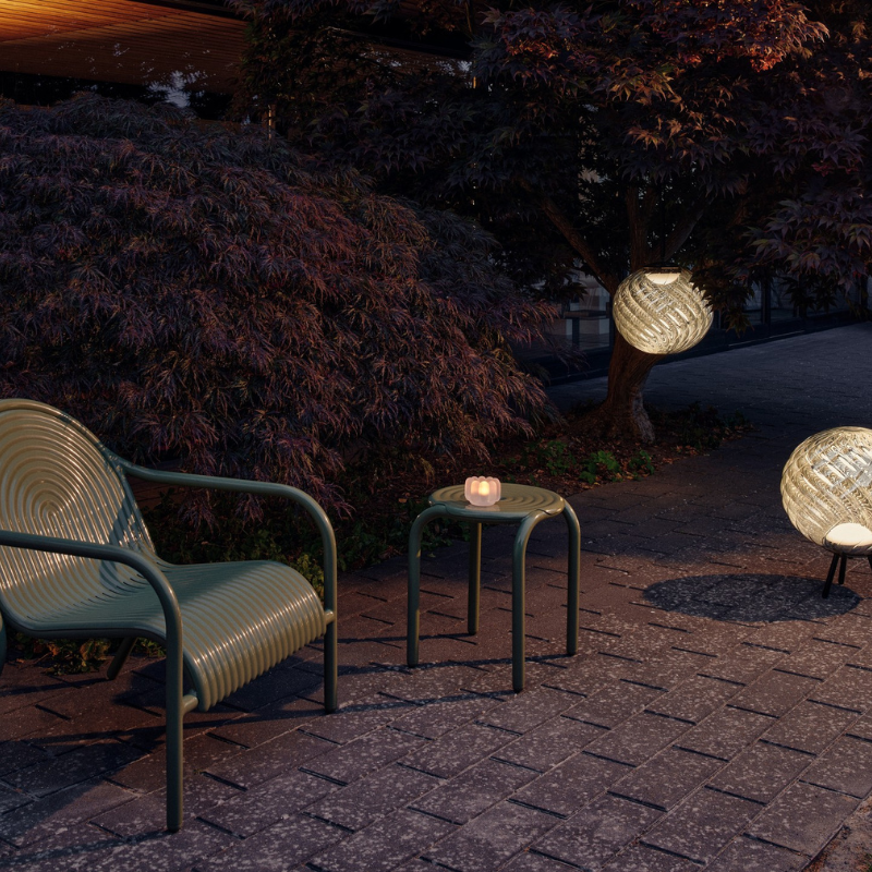 The Groove Outdoor Lounge Chair by Tom Dixon in Moss with matching stool.