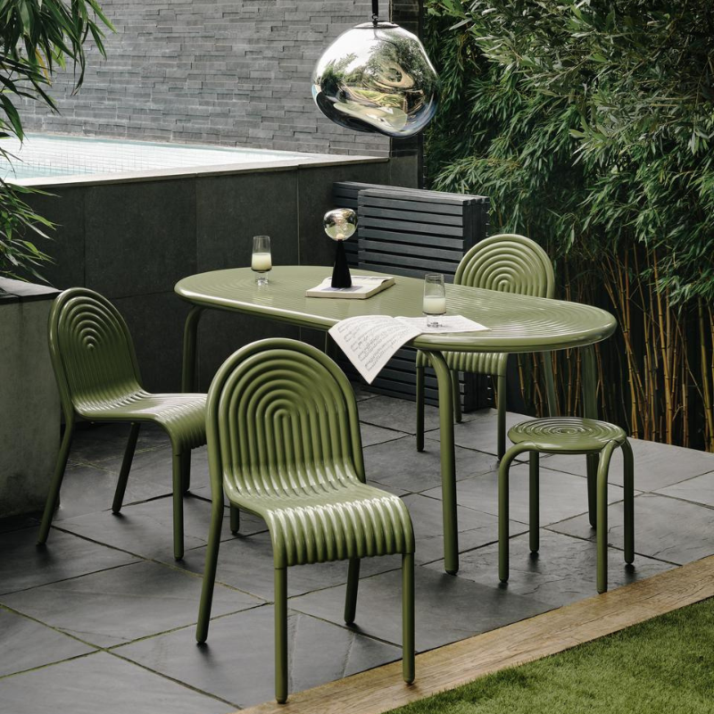 Outdoor Groove dining set in Moss by Tom Dixon on a patio.