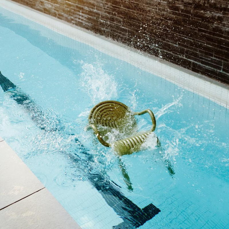 Moss green outdoor chair by Tom Dixon in swimming pool.