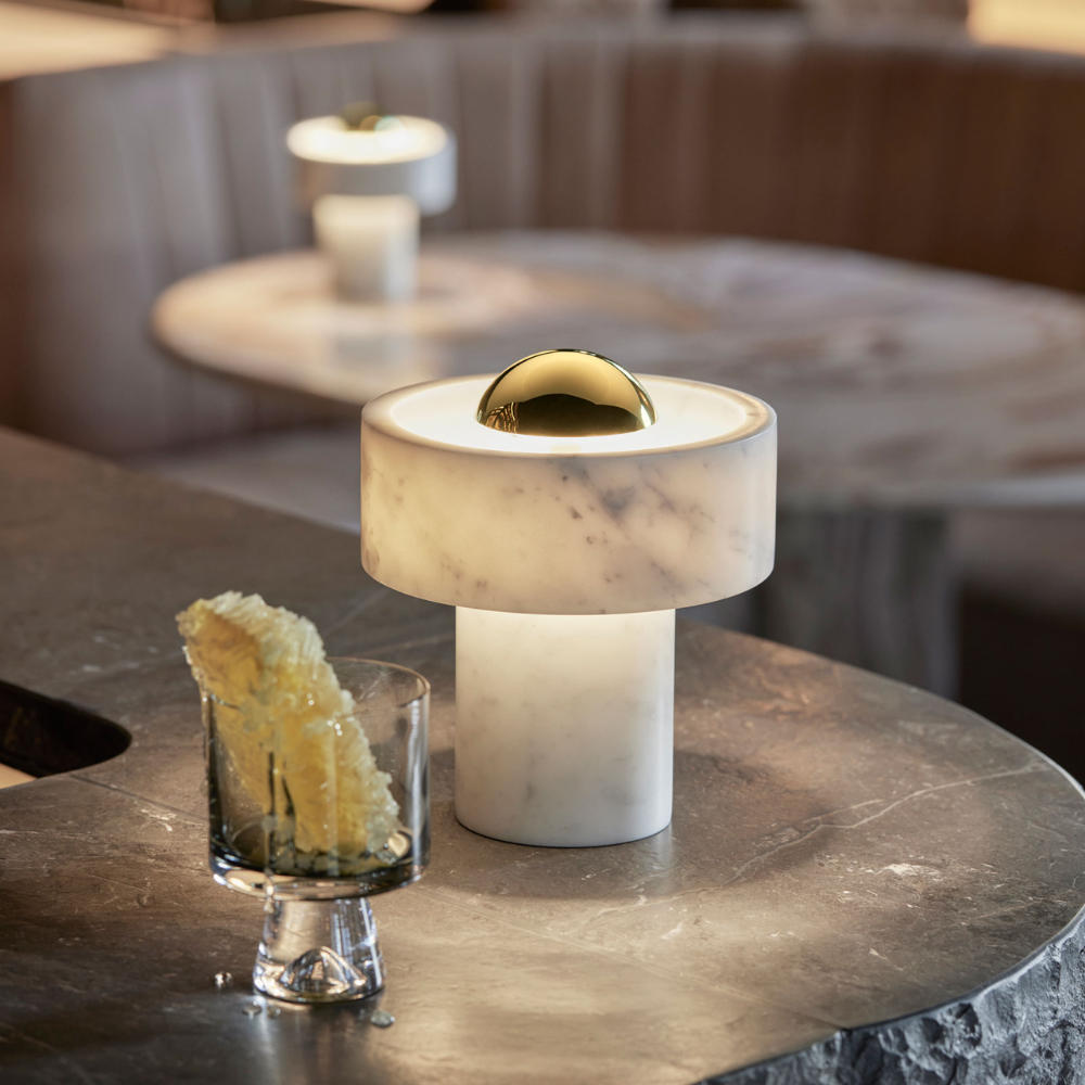 The Stone Portable Light by Tom Dixon in Brass on a restaurant bar.
